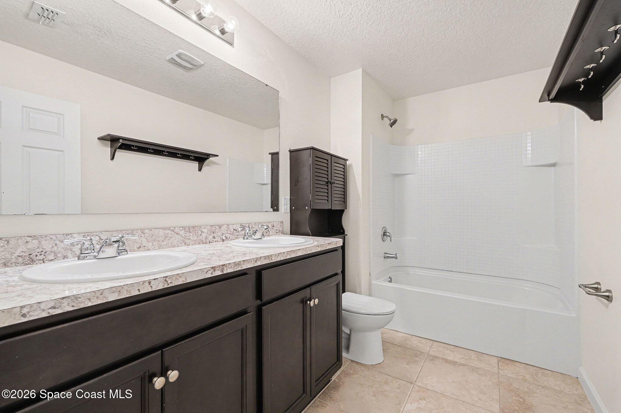 2535 Falcon Lane Mims, FL 32754 - Photo 26 of 31 a bathroom with a granite countertop sink toilet and shower