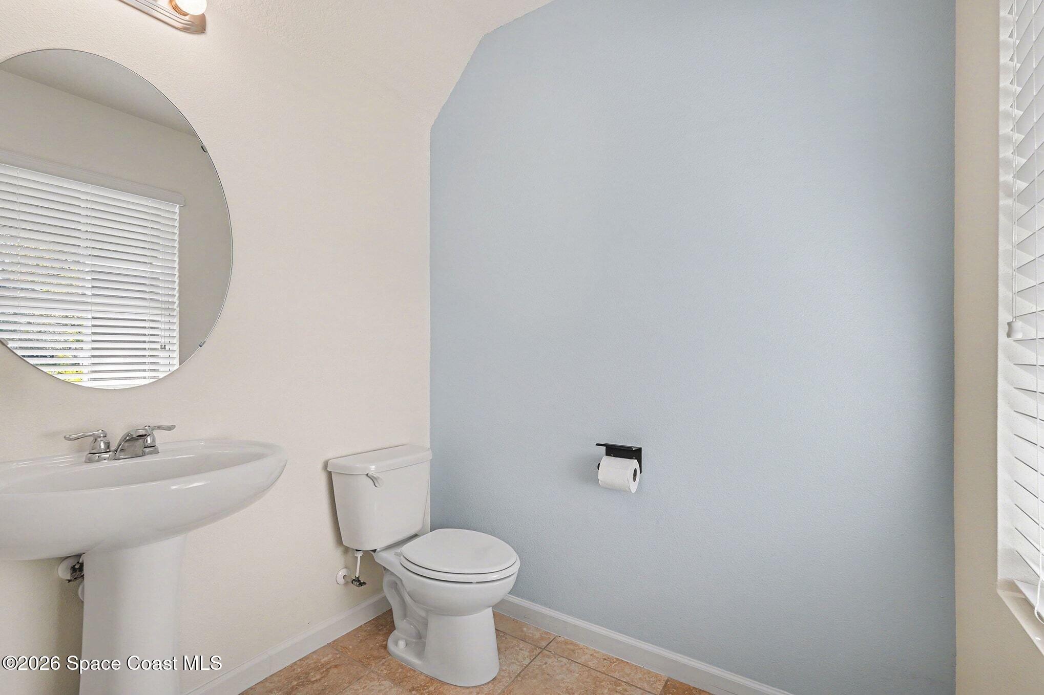 2535 Falcon Lane Mims, FL 32754 - Photo 7 of 31 a bathroom with a sink a toilet and a mirror