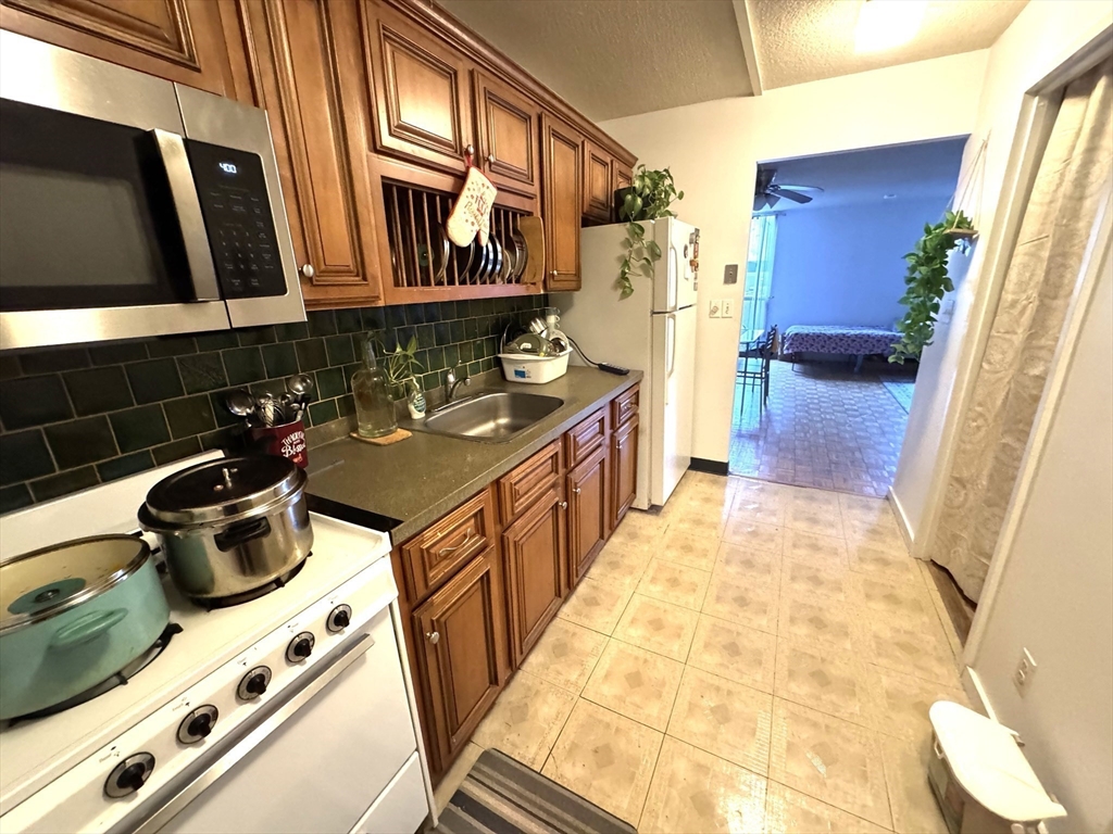 44 Washington Street, Unit 208 Brookline, MA 02445 - Photo 3 of 13 a kitchen with a stove and a refrigerator