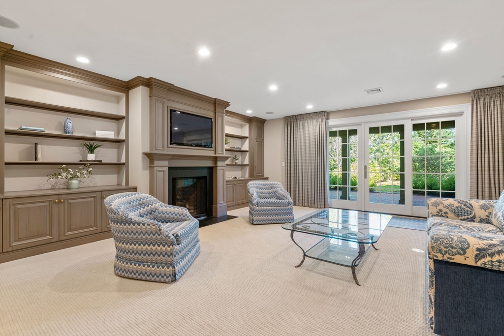 27 Pine Summit Circle, Unit 27 Weston, MA 02493 - Photo 32 of 42 a living room with furniture a flat screen tv and a fireplace