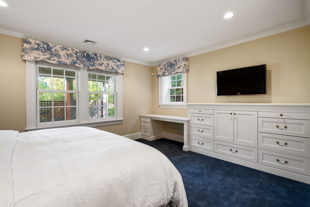 27 Pine Summit Circle, Unit 27 Weston, MA 02493 - Photo 36 of 42 a bedroom with a large bed and a flat screen tv