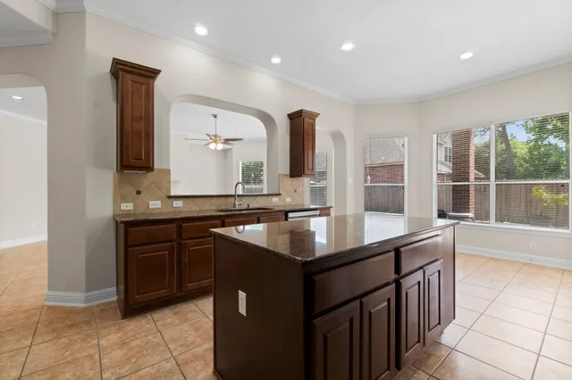 a kitchen with kitchen island granite countertop a sink and a stove