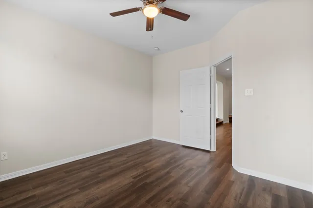 a view of a room with wooden floor and a ceiling fan