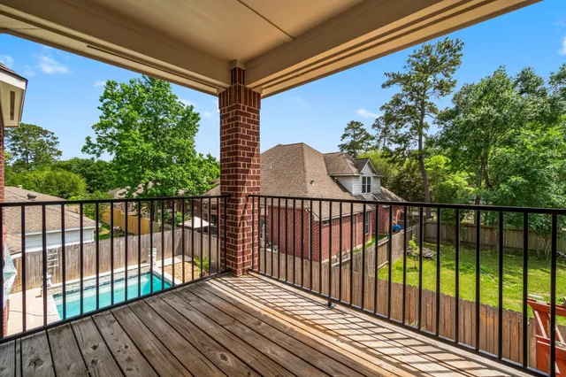 a view of an empty room with wooden floor ceiling fan