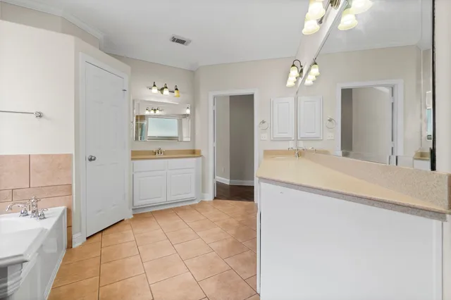 a bathroom with a granite countertop sink a large mirror and a bathtub