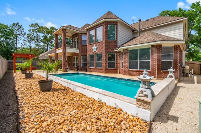 a backyard of a house with large trees and plants