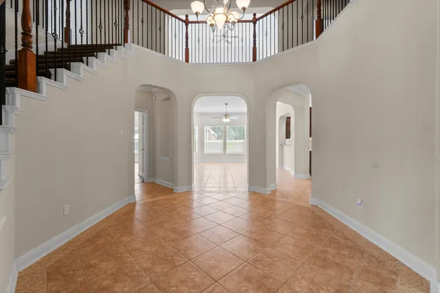 a view of a hallway with entryway and chandelier