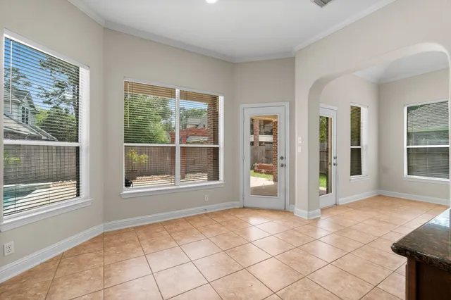 a view of an empty room with window and a livingroom
