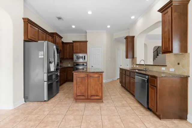 a kitchen with stainless steel appliances granite countertop a refrigerator and a stove