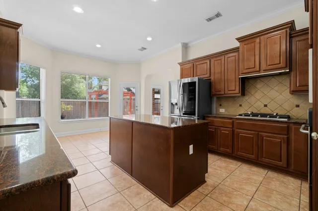 a kitchen with stainless steel appliances granite countertop a stove a sink and a microwave