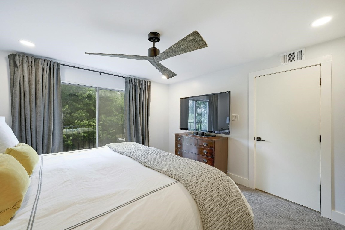 702 Castle Ridge Road, Unit B Austin, TX 78746 - Photo 15 of 23 a bedroom with a large bed and a large window