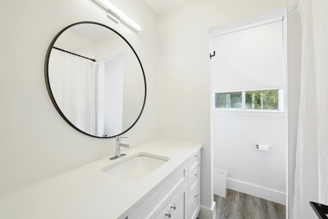 702 Castle Ridge Road, Unit B Austin, TX 78746 - Photo 16 of 23 a bathroom with a sink and a mirror