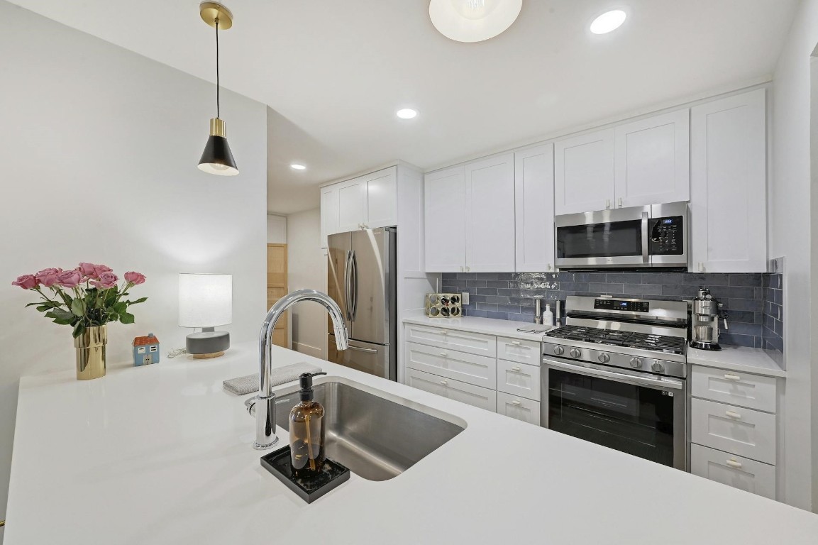 702 Castle Ridge Road, Unit B Austin, TX 78746 - Photo 3 of 23 a kitchen with a sink appliances and cabinets