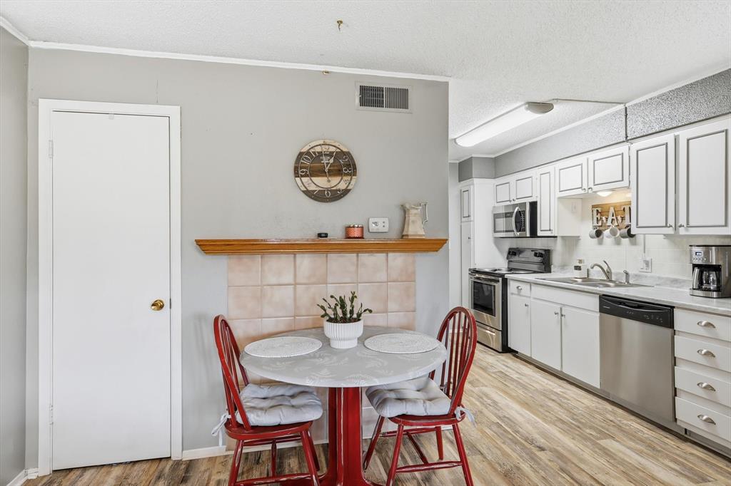 81 Runaway Bay Drive, Unit 220 Runaway Bay, TX 76426 - Photo 13 of 32 a view of a dining room with furniture and wooden floor