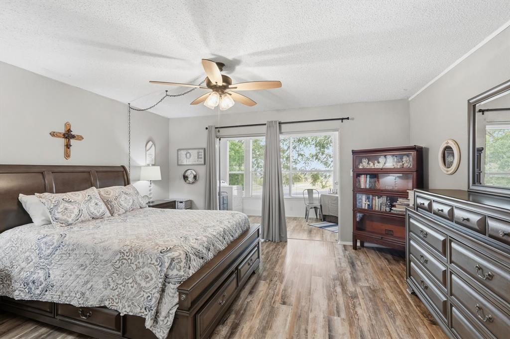 81 Runaway Bay Drive, Unit 220 Runaway Bay, TX 76426 - Photo 15 of 32 a bedroom with a bed and a chandelier