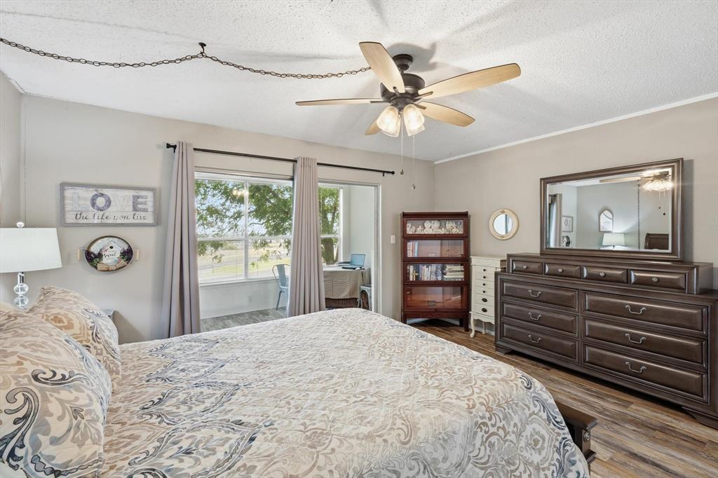 81 Runaway Bay Drive, Unit 220 Runaway Bay, TX 76426 - Photo 16 of 32 a bedroom with a bed and a chandelier