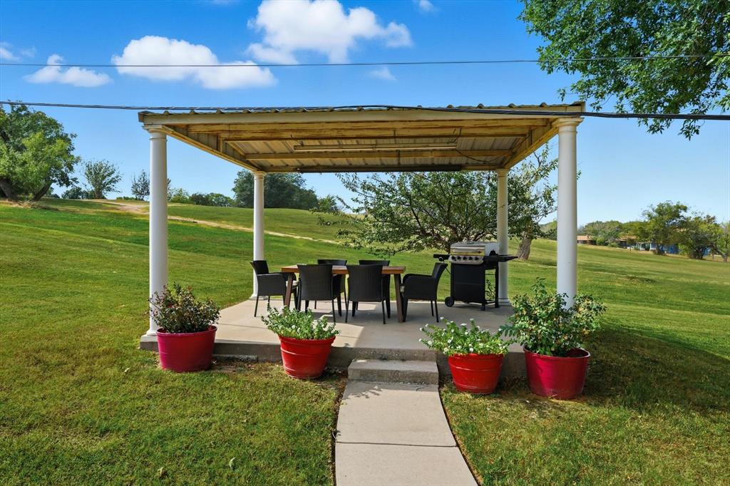 81 Runaway Bay Drive, Unit 220 Runaway Bay, TX 76426 - Photo 19 of 32 a view of a chair and table in the garden