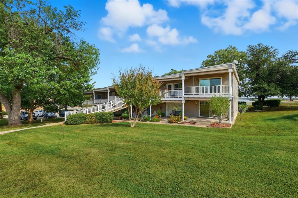 81 Runaway Bay Drive, Unit 220 Runaway Bay, TX 76426 - Photo 2 of 32 a view of a house with a yard