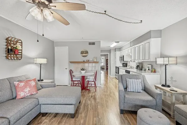 a living room with furniture and a wooden floor