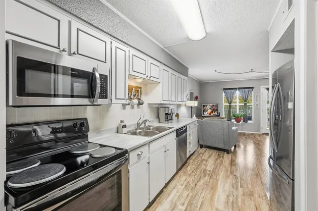 a kitchen with stainless steel appliances a stove sink microwave and cabinets