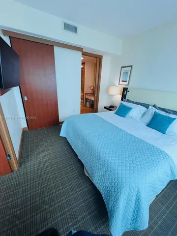 a bedroom with a bed next to a window