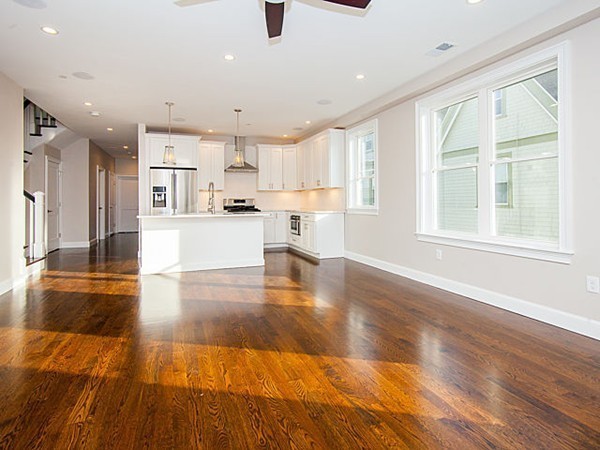 a large kitchen with stainless steel appliances granite countertop a refrigerator a sink dishwasher and a stove with wooden floor