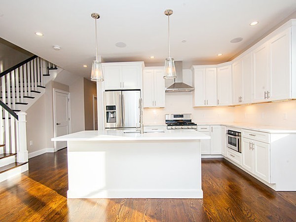 884 Adams Street, Unit 4 Boston, MA 02124 - Photo 4 of 27 a large kitchen with stainless steel appliances granite countertop a sink a stove a refrigerator and white cabinets