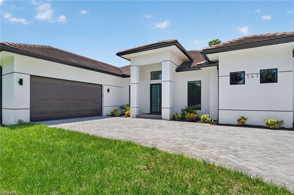 563 15th Street Northwest Naples, FL 34120 - Photo 3 of 22 a front view of a house with a yard and garage