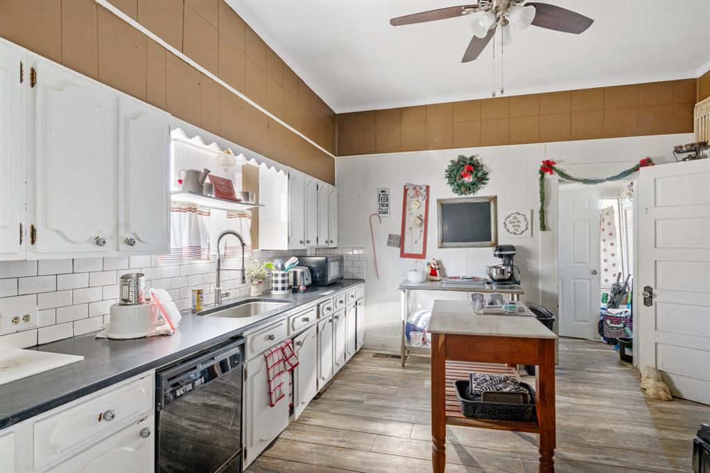 308 Race Street Baird, TX 79504 - Photo 11 of 27 Kitchen with black appliances, white cabinetry, and light wood-style floors