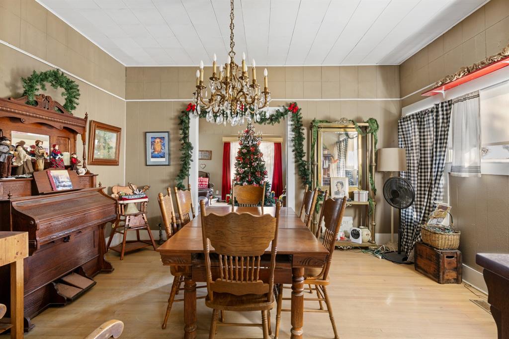 308 Race Street Baird, TX 79504 - Photo 12 of 27 Dining room with a chandelier, wood finished floors, and wooden walls