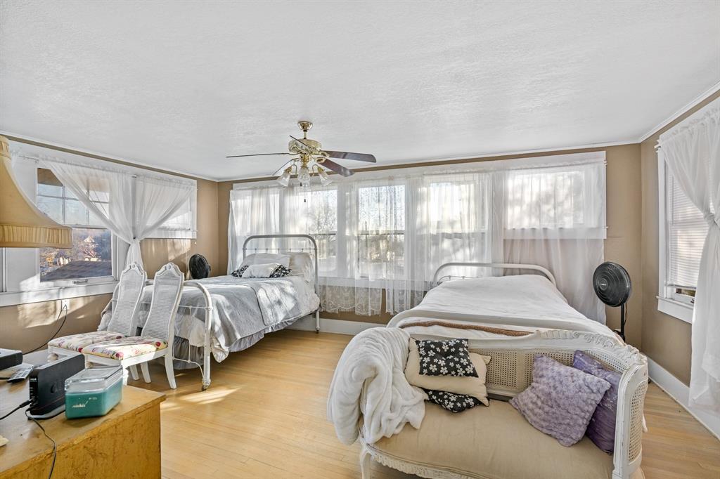 308 Race Street Baird, TX 79504 - Photo 24 of 27 Bedroom with light wood-style flooring, a ceiling fan, a textured ceiling, and ornamental molding