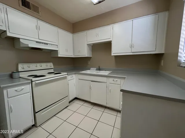a kitchen with white cabinets and white appliances