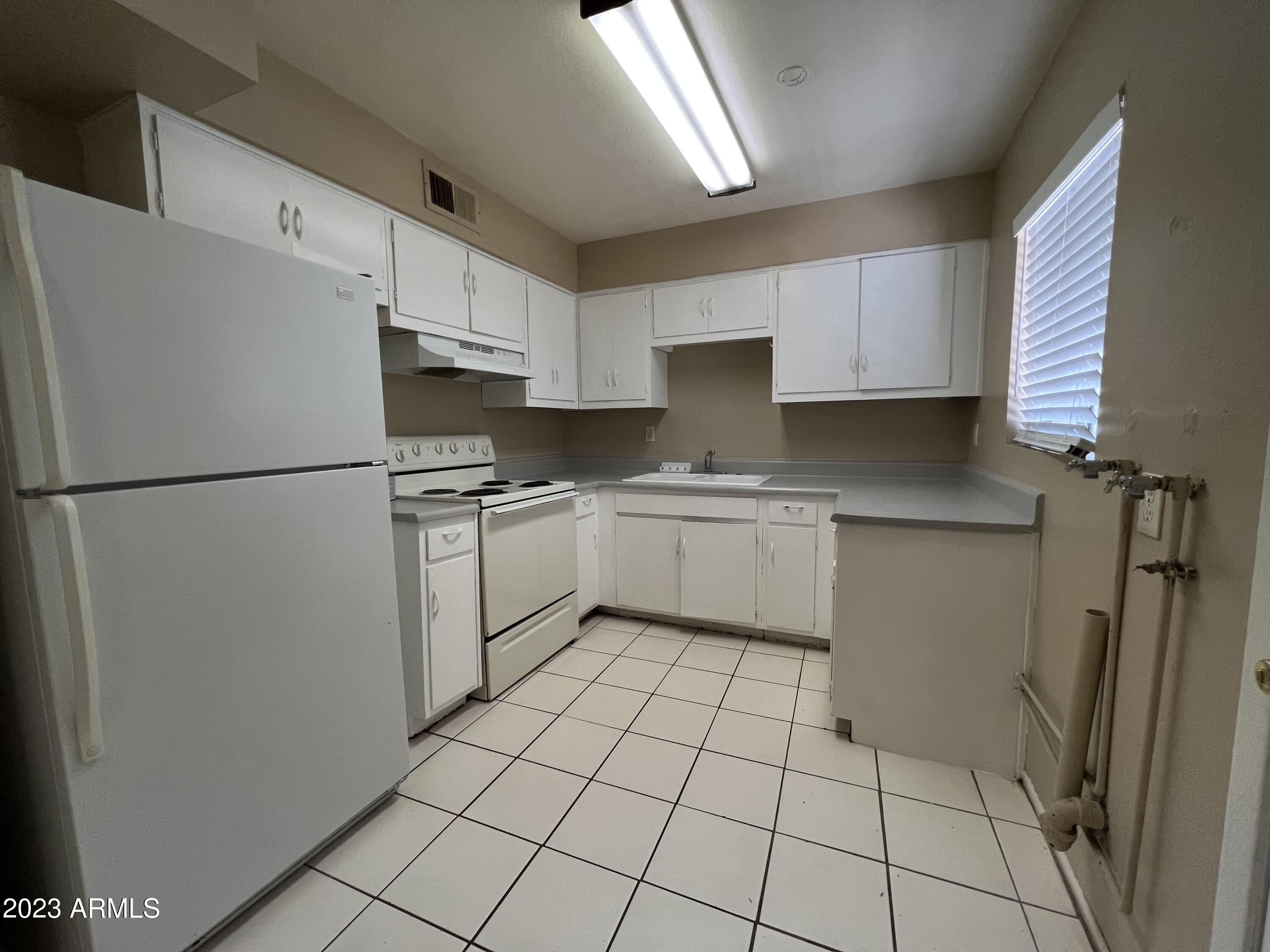 26 West 6th Place, Unit 3 Mesa, AZ 85201 - Photo 6 of 11 a kitchen with white cabinets and white appliances
