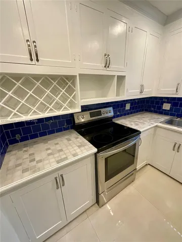a kitchen with granite countertop white cabinets and white appliances