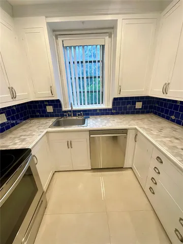 a view of a kitchen that has a sink a stove and a microwave