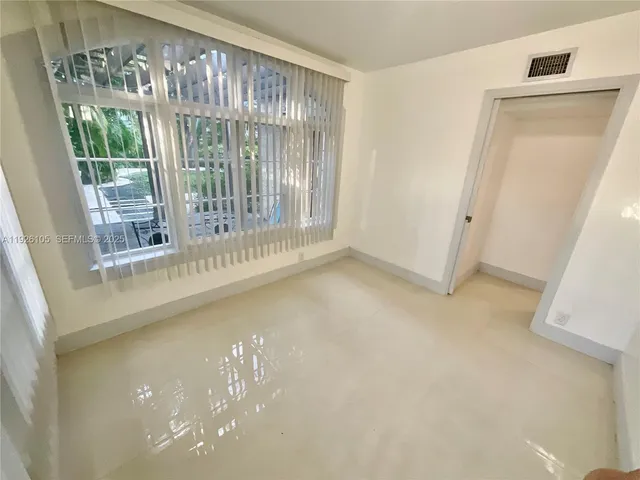 a view of empty room with floor to ceiling window and an entrance