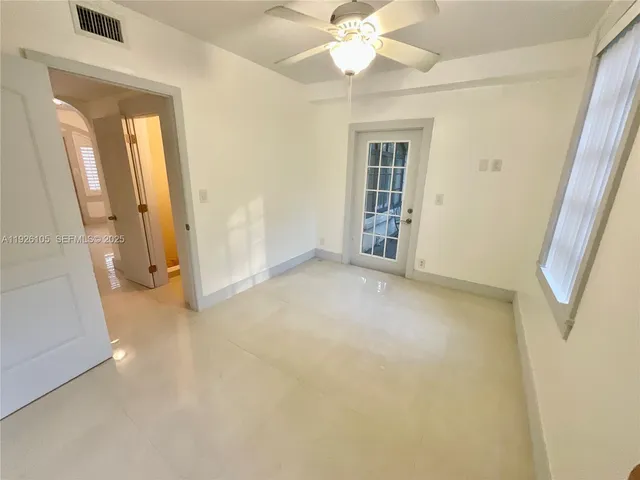 en empty room with windows and fan