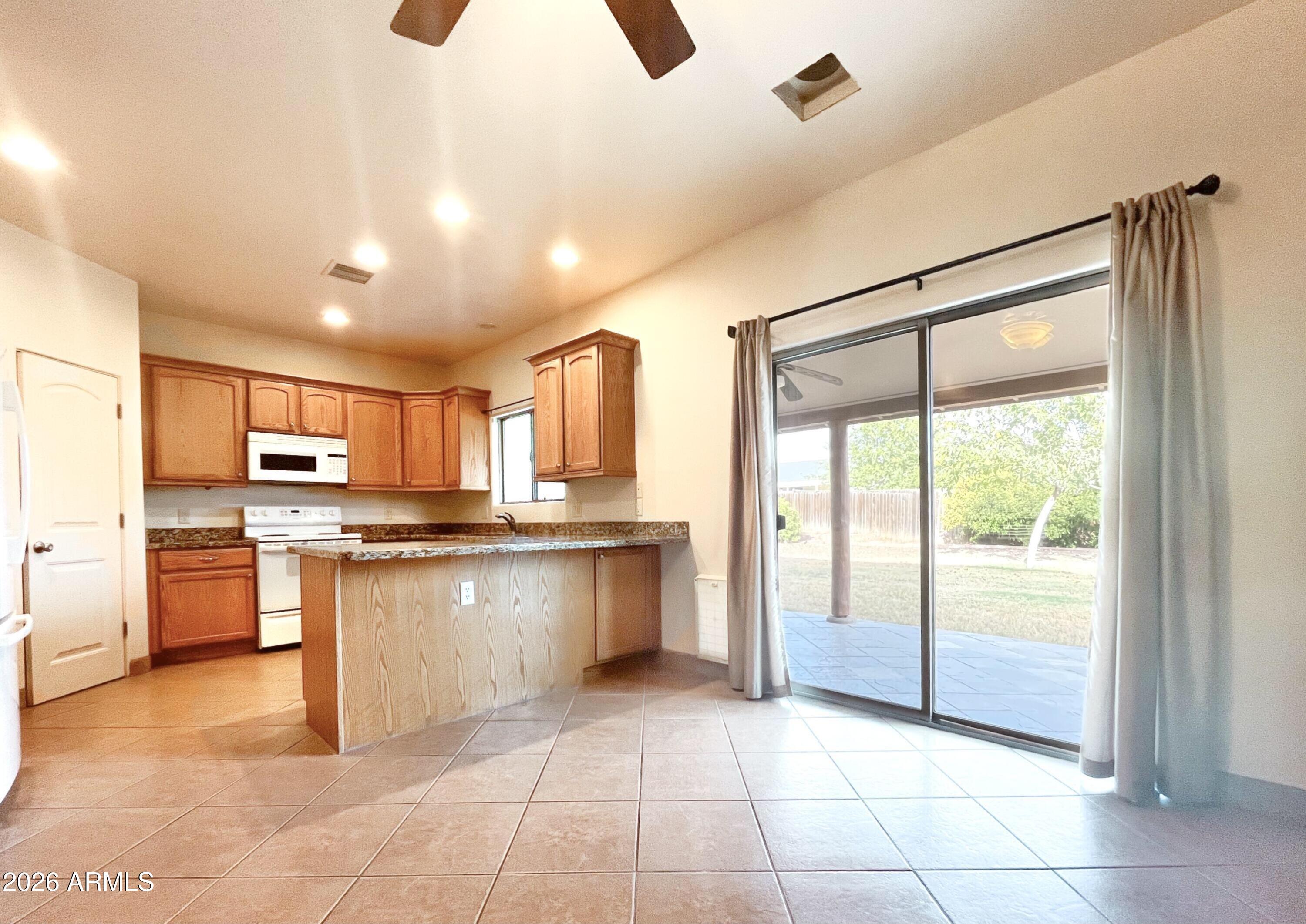 5655 North Laura Lane Rimrock, AZ 86335 - Photo 11 of 37 a large kitchen with stainless steel appliances granite countertop a refrigerator and a sink
