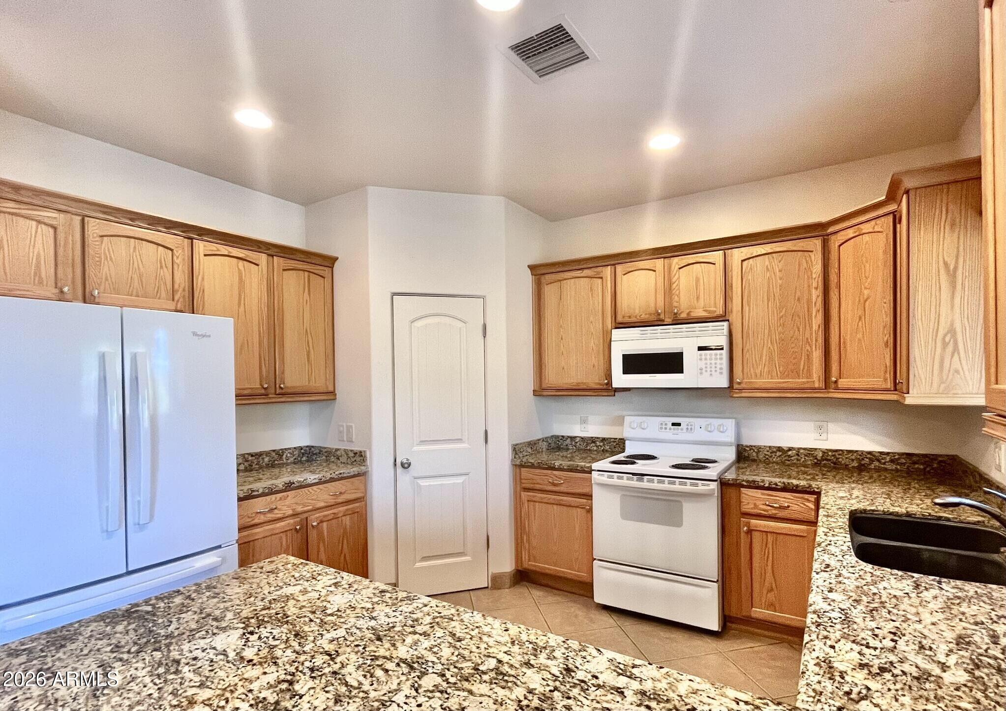 5655 North Laura Lane Rimrock, AZ 86335 - Photo 8 of 37 a kitchen with granite countertop a refrigerator and a stove top oven