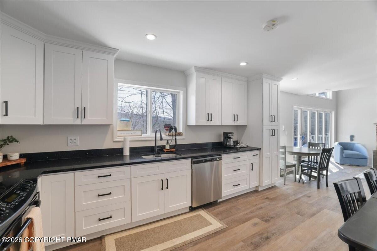5873 Decker Road Bushkill, PA 18324 - Photo 4 of 57 a kitchen with granite countertop a sink white cabinets and black appliances