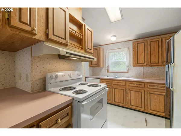 a kitchen with stainless steel appliances granite countertop a sink stove and cabinets