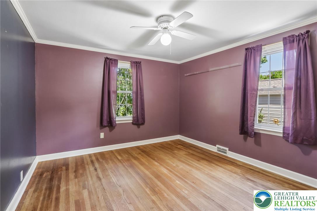 974 Juniper Road Hellertown, PA 18055 - Photo 18 of 48 Hardwood flooring extends throughout this naturally illuminated bedroom, complete with a ceiling fan for optimal comfort.