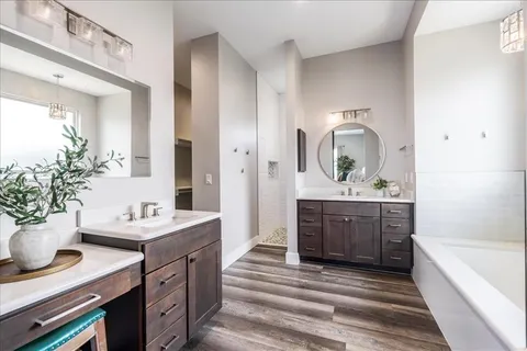 a spacious bathroom with a sink double vanity granite tub and shower