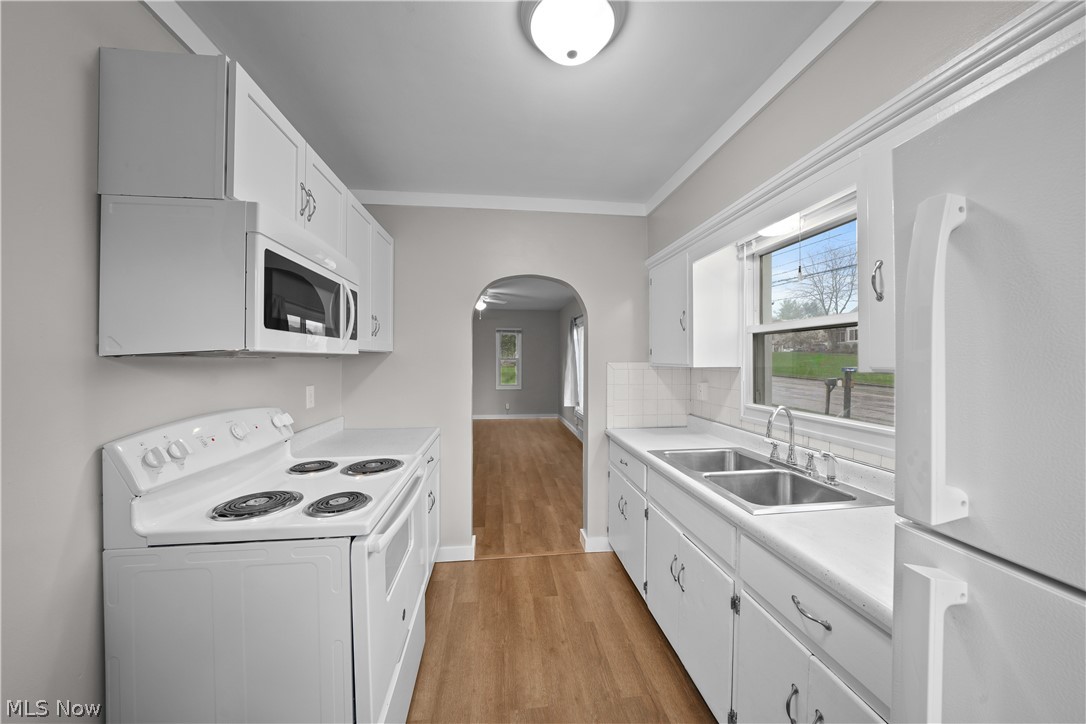 4814 Darrow Road Stow, OH 44224 - Photo 8 of 32 Kitchen with light hardwood / wood-style flooring, white appliances, crown molding, white cabinetry, and sink