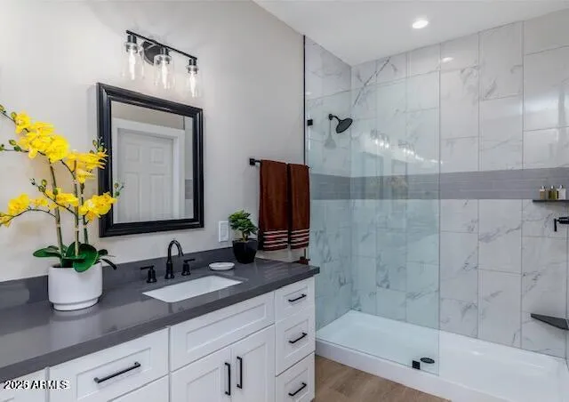 a bathroom with a granite countertop sink a potted plant and shower