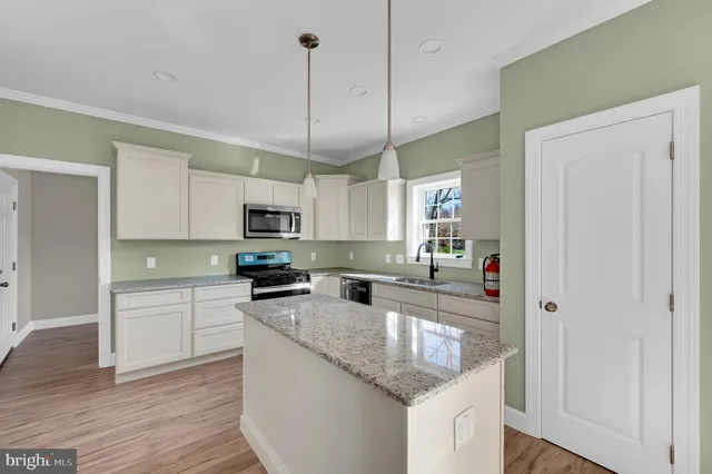 a kitchen with stainless steel appliances granite countertop a sink a stove and refrigerator