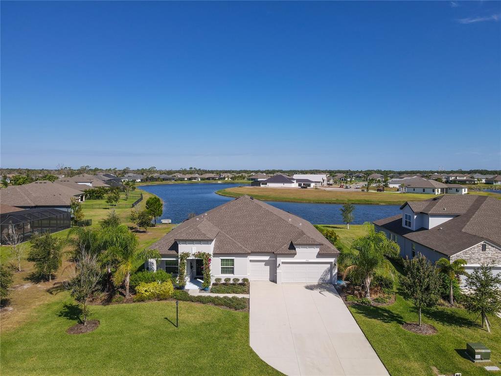 an aerial view of a house with a garden and lake view