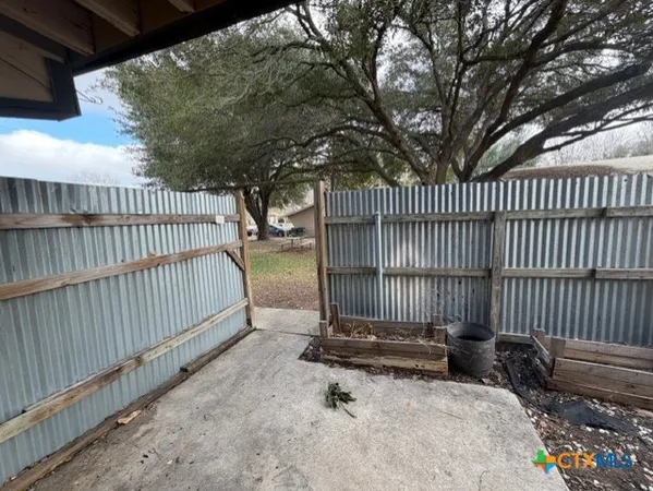 a view of backyard with wooden fence