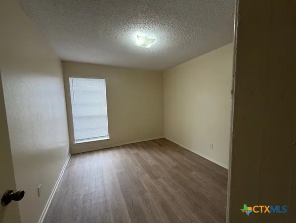 an empty room with wooden floor and closet