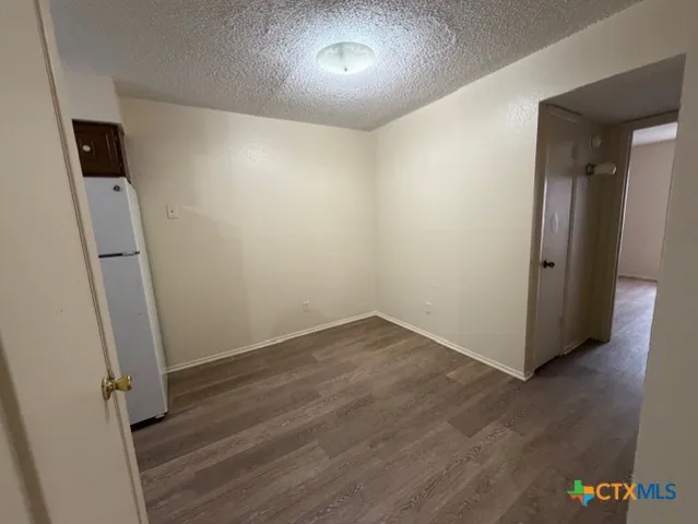 an empty room with wooden floor and a window
